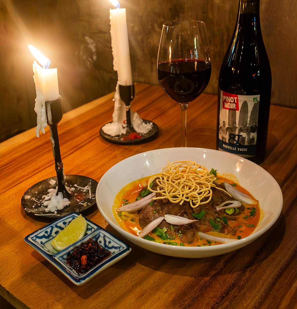 Un Khao Soi aux chandelles accompagné d'un verre de vin, chez Ban Sue.